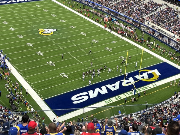 Football stadium with field logo and packed stands viewed from the upper seating area during a game. — Los Angeles