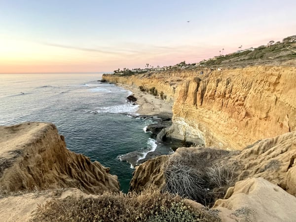 Sandstone sea cliffs with eroded columnar formations overlooking the Pacific Ocean at sunset, viewed from clifftop… — San Diego