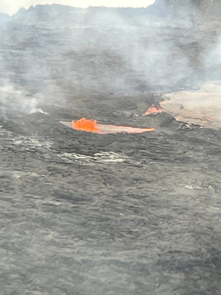 Active lava flow with bright orange molten streams across dark volcanic field, photographed from volcanic terrain. — Hawaiʻi Volcanoes National Park, Big Island, Hawaii