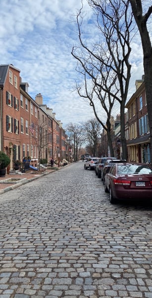 Historic brick rowhouses line a cobblestone street in Philadelphia's Old City neighborhood, viewed from street level. — Center City, Philadelphia
