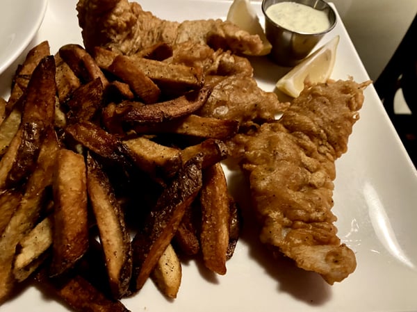 Fried chicken and seasoned potato wedges served with lemon and white dipping sauce on a white plate. — South Philadelphia, Philadelphia