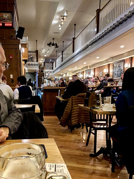 Interior of a busy casual dining restaurant with counter seating, wooden tables, and industrial ceiling fixtures filled… — Center City, Philadelphia