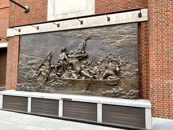 Bronze relief sculpture depicting a historical maritime scene mounted on a brick building facade in Philadelphia. — Museum of the American Revolution, Philadelphia