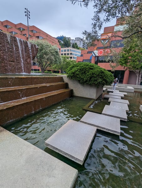 Modern brick buildings with a contemporary water feature and stepping stones in an urban plaza setting. — Financial District, San Francisco