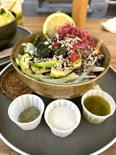 Artfully plated salad bowl with seaweed, avocado, microgreens, and sesame seeds, accompanied by condiments including… — Oltrarno, Florence