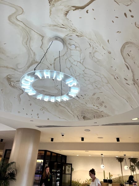Neon sign hanging from an ornate ceiling in a modern hotel lobby in Santa Monica, California. — Downtown Santa Monica, Los Angeles