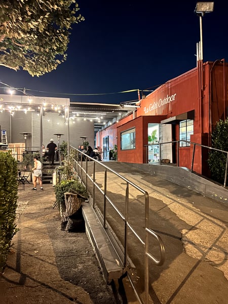 Le Great Outdoor restaurant at night in Santa Monica, featuring an illuminated red corrugated metal structure with… — Los Angeles