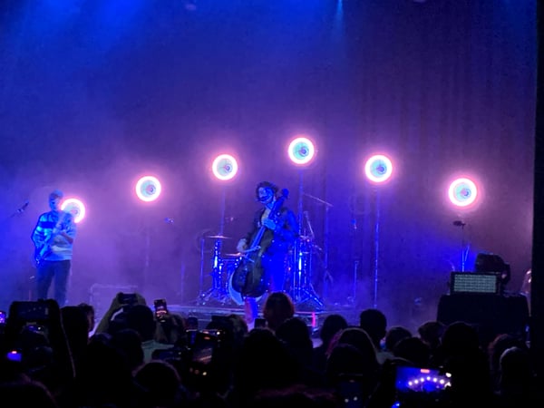 Live music performance with band on stage under pink and blue neon circular lights, viewed from the audience. — Hollywood, Los Angeles