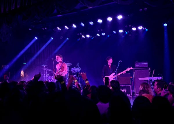 Live rock band performing on stage with purple stage lighting and crowd in venue on Sunset Boulevard, West Hollywood. — Los Angeles