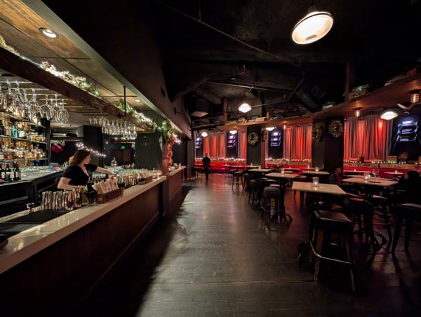 Interior of an upscale bar with red-draped windows, full bar counter, and festive holiday decorations during evening… — Financial District, San Francisco