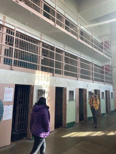 Interior of Alcatraz Main Cell House showing numbered prison cells with barred doors and upper tier galleries. — Alcatraz Main Cell House, San Francisco