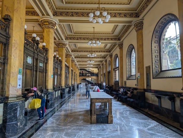 Grand neoclassical corridor with ornate coffered ceiling, marble columns, and arched windows in a historic Mexico City… — Centro, Mexico City