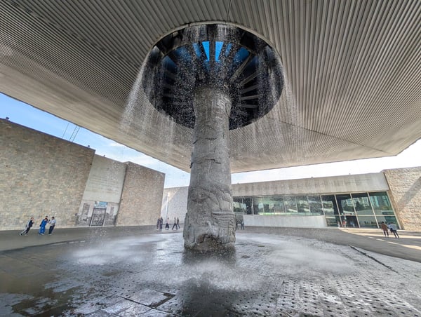 Modern architectural plaza with a central cylindrical column featuring a water fountain and blue accent lighting… — Polanco, Mexico City