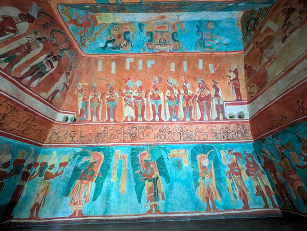 Ancient Maya mural ceiling depicting hieroglyphics, seated figures, and winged deities in blue and red pigments, viewed… — Polanco, Mexico City