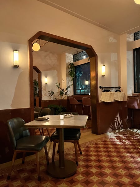 Modern hotel restaurant or café interior with wooden architectural elements, dining tables, and evening ambient… — Roma, Mexico City
