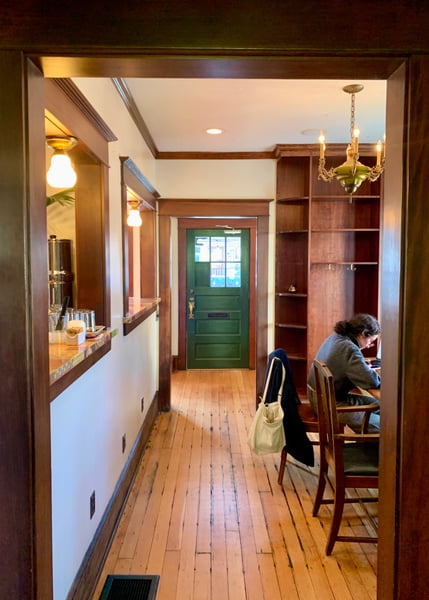 Interior hallway of a historic Portland building with wood beams, green entry door, and period fixtures viewed from the… — Buckman, Portland