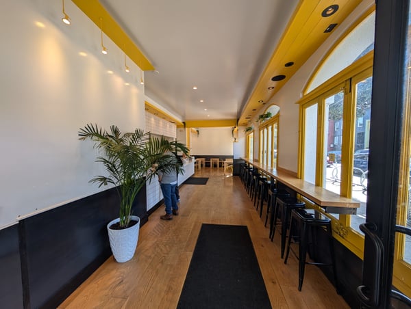 Modern café interior with yellow-framed windows, wooden counter seating, and contemporary design on 18th Street, San… — Castro District, San Francisco