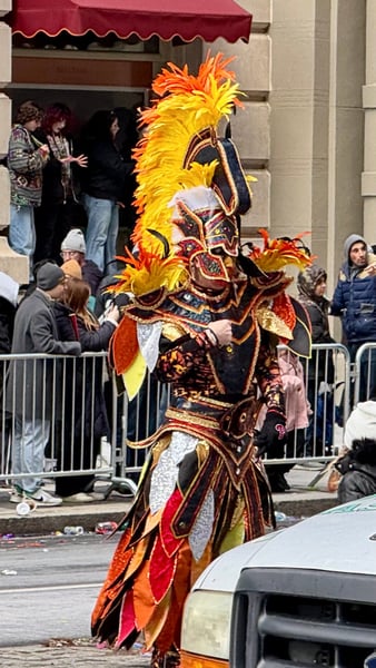 Elaborately costumed performer with vibrant feathered headdress at a street parade in Philadelphia. — Center City, Philadelphia