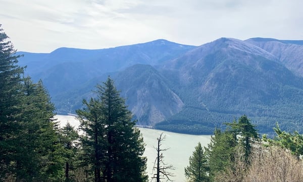 Alpine lake surrounded by forested mountains viewed from a hillside vantage point in the Cascade Range. — Columbia River Gorge