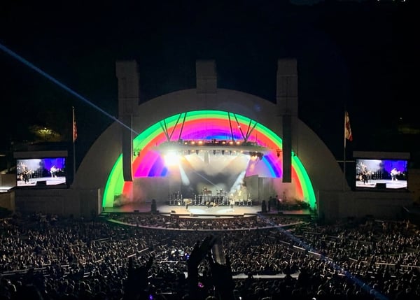 Large concert or music event at the Hollywood Bowl with illuminated stage canopy and crowd of thousands of attendees. — Hollywood, Los Angeles