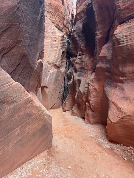Narrow red sandstone slot canyon with towering walls and sandy floor near Kanab, Utah. — The Wave Trail, Kanab & The Wave
