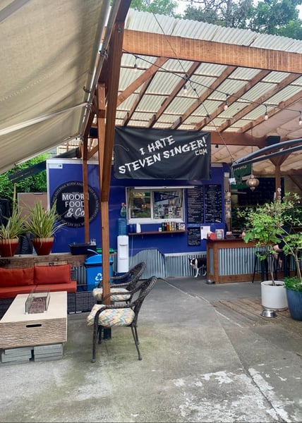 Outdoor food vendor stall with blue storefront and covered seating area on Belmont Street in Portland, Oregon. — Sunnyside, Portland