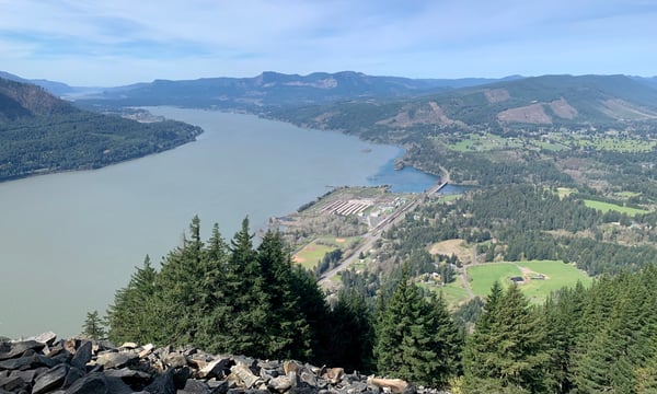 Large alpine lake surrounded by forested mountains and valleys, viewed from a rocky ridge with coniferous trees in… — Columbia River Gorge