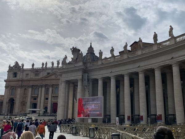 St. Peter's Basilica with its distinctive dome and colonnade viewed from St. Peter's Square during daytime with crowds… — Borgo, Rome