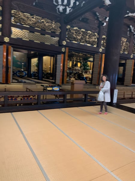 Interior courtyard of a traditional Japanese temple or shrine in Kyoto, with tatami mat flooring and ornate dark wooden…